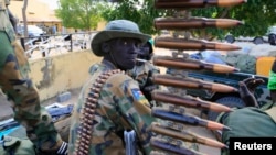 FILE - A South Sudan army soldier stands next to a machine gun mounted on a truck in Malakal town, some 500 km (312 miles) northeast of the capital, Juba.
