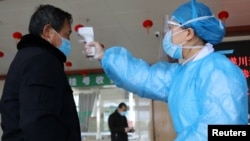 បុគ្គលិក​ពេទ្យ​វាស់​សីតុណ្ហភាព​របស់​បុរស​ម្នាក់​នៅ​ច្រក​ចូល​មន្ទីរពេទ្យ នៅ​ពេល​មាន​ការ​ផ្ទុះ​ឡើង​នូវ​មេរោគ​កូរ៉ូណា​ប្រភេទ​ថ្មី នៅ​ក្នុង​ក្រុង Suichuan ខេត្ត Jiangxi ប្រទេស​ចិន កាលពី​ថ្ងៃទី២ ខែកុម្ភៈ ឆ្នាំ២០២០។