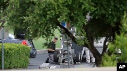 FILE - Police appear to set up a remotely operated robot during a stand-off with a gunman barricaded inside a van at a Jack in the Box restaurant in Hutchins, Texas. 