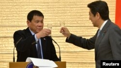 រូបឯកសារ៖ ប្រធានាធិបតី​ហ្វីលីពីន Rodrigo Duterte ជល់កែវ​ជាមួយ​លោក Shinzo Abe នាយក​រដ្ឋ​មន្ត្រី​ជប៉ុន​ នៅគេហដ្ឋាន​របស់​លោក​ Abe នៅ​ទីក្រុង​តូក្យូ ប្រទេស​ជប៉ុន កាល​ពី​ឆ្នាំ​២០១៦។