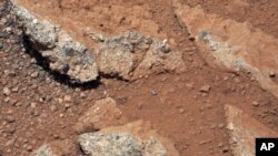 This image provided by NASA shows shows a Martian rock outcrop near the landing site of the rover Curiosity thought to be the site of an ancient streambed. Curiosity landed in a crater near Mars' equator on Aug. 5, 2012, on a two-year mission to study whe