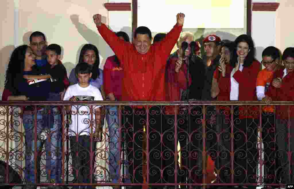 Venezuelan President Hugo Chavez (C) gestures while speaking to supporters after receiving news of his reelection in Caracas.