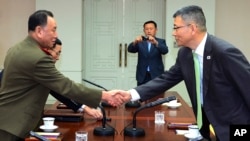 Pejabat pertahanan Korea Utara (kiri) berjabat tangan dengan mitranya dari Korsel dalam pembicaraan di Panmunjom, Korea Selatan Rabu (15/10).
