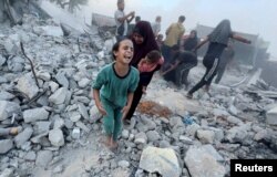 Palestinci na ostacima zgrade srušene u izraelskom udaru, nedaleko od škole UN, u Kan Junisu, na jugu Pojasa Gaze, 3. jula 2024.