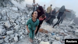 Palestinians react following an Israeli strike near a U.N.-run school sheltering displaced people in Khan Younis, Gaza Strip, in this still image taken from a video, July 3, 2024.
