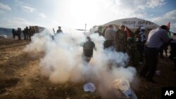 지난해 11월 요르단강 서안 지역에서 유대인 정착촌 건설을 위한 기존 시설 해체작업에 항의하던 팔레스타인 주민들이 이스라엘군의 진압활동에 몸을 피하고 있다. 