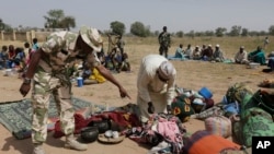 Des soldats fouillent les gens qui fuient du carnage de Boko Haram au Nigeria 8 décembre 2015. 