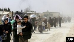 Warga sipil melarikan diri dari wilayah Hammuriyé di daerah kantong pemberontak Ghouta Timur, setelah sekitar satu bulan melakukan pemboman oleh rezim Suriah, 15 Maret 2018.