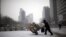 FILE - A man carries scraps in a handcart during snowfall in central Seoul, South Korea, Feb. 16, 2016. With the recycling market dimming, Seoul is turning to upcycling to reduce waste.
