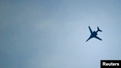 FILE - A U.S.-led coalition aircraft flies over Kobanii, as seen near the Mursitpinar border crossing on the Turkish-Syrian border in the southeastern town of Suruc in Sanliurfa province.