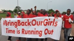 FILE - People shout slogans and hold a banner during a demonstration in Abuja, Nigeria.