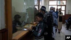 Petugas Taliban memeriksa paspor di Islam Qala, perbatasan Afghanistan-Iran, 24 November 2021. (AP Photo/Petros Giannakouris)