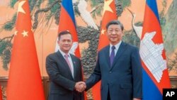 រូបឯកសារ៖ នាយករដ្ឋមន្ត្រីកម្ពុជា លោក ហ៊ុន ម៉ាណែត ចាប់ដៃជាមួយប្រធានាធិបតីចិនលោក Xi Jinping ក្នុងអំឡុងជំនួបមួយ នៅទីក្រុងប៉េកាំង ប្រទេសចិន កាលពីថ្ងៃទី ១៥ ខែកញ្ញា ឆ្នាំ ២០២៣។ (Cambodia's Prime Minister Telegram via AP)