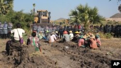 FILE - Farmers confront riot police at Letpadaung copper mine, Monywa in northwestern Myanmar, Dec. 22, 2014. 