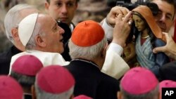 Pope Francis is shown a statuette of the Virgin Mary during an audience with Roma, Sinti and others itinerant group members, at the Vatican, Monday, Oct. 26, 2015.