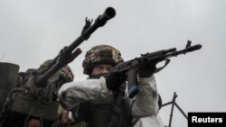 Seorang prajurit Ukraina menodongkan senjata ke atas tank selama latihan militer di perbatasan dengan Belarus, dekat Chornobyl, Ukraina 3 Februari 2023. (Foto: REUTERS/Viacheslav Ratynskyi)