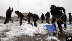Petugas dari kepolisisan Tiongkok membersihkan salju yang menyelimuti lapangan Tiananmen di Beijing (4/11).