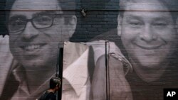 រូបឯកសារ៖ រូបថតរបស់ពលរដ្ឋអាមេរិកាំងពីរនាក់ដែលត្រូវបានឃុំខ្លួននៅអ៊ីរ៉ង់ ត្រូវបានបញ្ចាំងលើអគារមួយនៅរដ្ឋធានីវ៉ាស៊ីនតោន កាលពីថ្ងៃទី ២០ ខែកក្កដា ឆ្នាំ ២០២២។ 