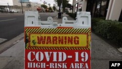 Sebuah papan peringatan bertuliskan "Wilayah Risiko Tinggi COVID-19" di tengah melonjaknya kasus infeksi COVID-19 di Los Angeles, 22 Januari 2021. 