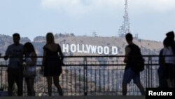 Para turis memperhatikan tanda Hollywood saat mengunjungi kompleks perbelanjaan di Hollywood Boulevard, Hollywood, California, 3 Agustus 2017. (Foto: Reuters)