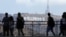 FILE - Tourists walk past the Hollywood sign as they visit a shopping complex along Hollywood Boulevard in Hollywood, California, Aug. 3, 2017.