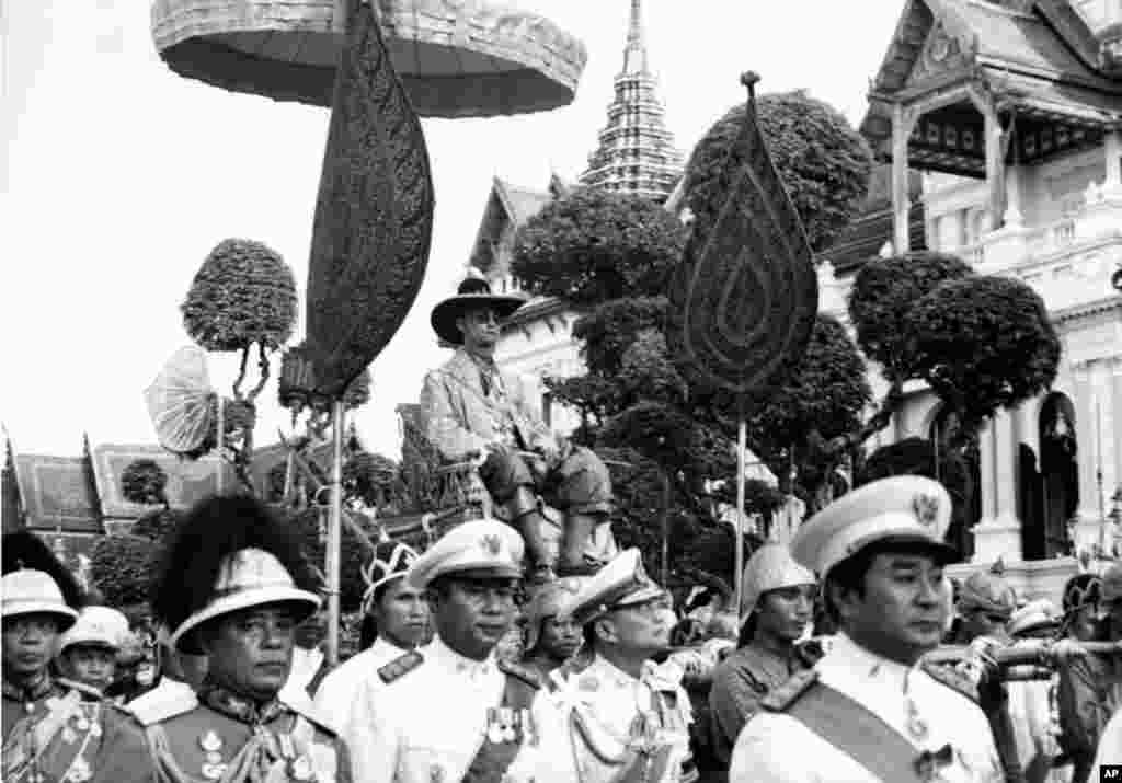 Raja Bhumibol Adulyadej ditandu pengawal kerajaan dalam parade di Bangkok, 1963.