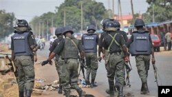 Police officers patrol outside the court, where suspected rioters awaited a court hearing in Kaduna, Nigeria.