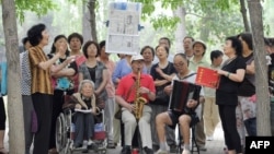 资料照：一组退休人员在北京公园里唱红歌。