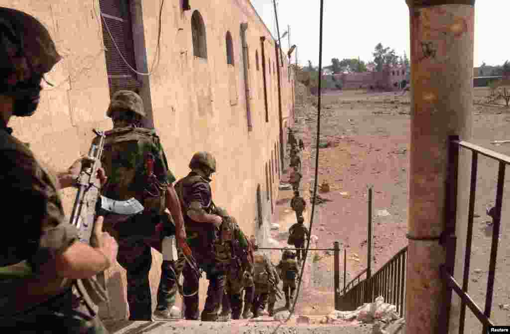 Forces loyal to Syria's President Bashar al-Assad are seen at Hanano barracks after clashes with Free Syrian Army forces, Aleppo, Syria, October 7, 2012.