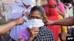Volunteers from the Diocese of Amritsar Church of North India distribute face masks to people during a government-imposed nationwide lockdown as a preventive measure against COVID-19 in Amritsar on April 15, 2020. 