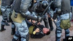 FILE - Police officers detain a person during an unsanctioned rally in Moscow, July 27, 2019.