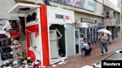 A man walks past a damaged road in Taksim Square where police and anti-government protesters clashed in central Istanbul, June 2, 2013. 