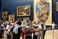 Pengunjung menyaksikan lukisan Leonardo da Vinci, Mona Lisa, di Paris, Senin, 6 Juli 2020.
