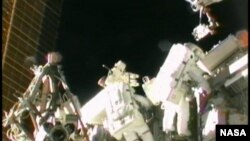 Astronot AS Sunita Williams (kanan) saat melakukan perbaikan stasiun antariksa internasional (foto: dok). 