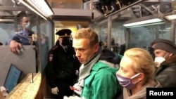 Foto yang diambil dari video tampak para petugas penegak hukum berbicara dengan pemimpin oposisi Rusia, Alexei Navalny, sebelum membawanya, di Bandara Sheremetyevo di Moskow, Rusia, Minggu, 17 Januari 2021. (Foto: Reuters)