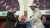 Le général Mohammed Hamdan Dagalo, et le leader du mouvement pour la démocratie au Soudan, Ahmad al-Rabiah, se serrent la main après la signature à Khartoum d'un document de partage du pouvoir au Soudan, mercredi 17 juillet 2019. 