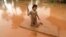 A girl uses a mattress as a raft during the flood after the Xe Pian Xe Namnoy hydropower dam collapsed in Attapeu province, Laos July 26, 2018.