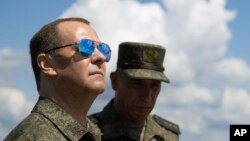 Wakil Ketua Dewan Keamanan Rusia dan Ketua Partai Rusia Bersatu Dmitry Medvedev, kiri, mengunjungi tempat latihan militer Totsky di wilayah Orenburg, Rusia, 14 Juli 2023. (Foto: via AP)