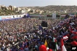Hezbollah Supporters gather at a soccer field, as they listen to Iranian President Mahmoud Ahmadinejad's speech during a rally organized by Hezbollah in the southern border town of Bint Jbeil, Lebanon, on 14 Oct., 2010.