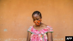 FILE - A woman checks her phone in Yaounde, Cameroon, April 23, 2020. An International Crisis Group report has found hate speech spread through social media to be a major contributor to ethnic and political tensions in the country. 