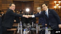 남북 고위급회담 한국 측 수석대표인 조명균 통일부 장관과 북한 측 수석대표 리선권 조국평화통일위원회(조평통)위원장이 13일 판문점 북쪽 지역인 통일각에서 회담에 앞서 악수하고 있다.