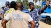 A policeman gestures at a journalist during a sit-in near the presidency, to protest against a new media law in Lome, Togo, March 14, 2013. 