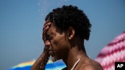 Čovjek se rashlađuje na plaži Ipanema u Rio de Žaneiru u Brazilu, 24. septembra 2023. (Foto: AP/Bruna Praddo).