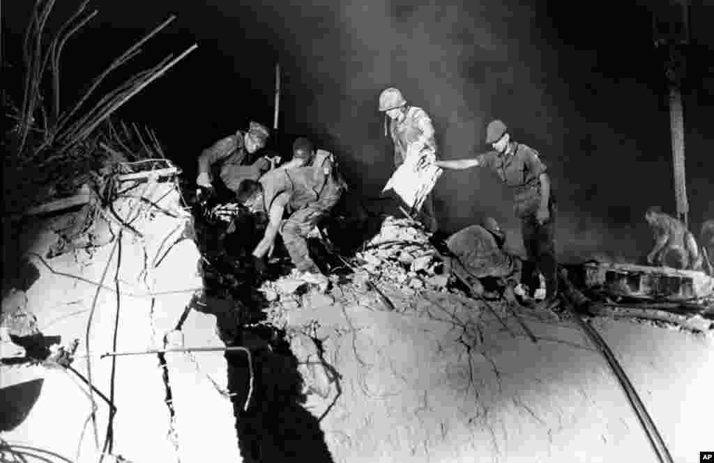 FILE - U.S. Marines and an Italian soldier, right, dig through the rubble of the the U.S. Marine barracks in Beirut, Lebanon, Oct. 23, 1983. 