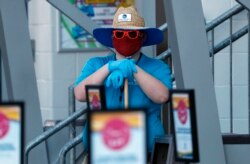 A worker stands ready to clean as waterparks reopened amid concerns of the spread of COVID-19, at the city-owned waterpark in Grand Prairie, Texas.