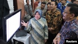 Walikota Surabaya Tri Rismaharini menunjukkan cara mengakses perizinan lewat Internet kepada ORI Jatim dan pengusaha. (VOA/Petrus Riski)