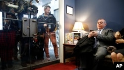 Lev Parnas, a Rudy Giuliani associate with ties to Ukraine, looks at his phone as he waits in the office of Senate Minority Leader Sen. Chuck Schumer of N.Y., on Capitol Hill in Washington, Jan. 29, 2020.
