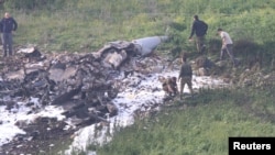 Pasukan keamanan Israelberjalan di dekat reruntuhan pesawat tempur F-16 dekat desa Harduf, Israel, 10 Februari 2018. 