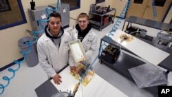 FILE - High School students P.J. Perkins, left, and Dylan DiBernardo in a manufacturing lab at Great Bay Community College in Rochester, N.H. Jan. 4, 2019 where they study for manufacturing certificates. (AP Photo/Charles Krupa)