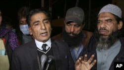 File - Lawyer Nadeem Ahmed Azar, L, and Sheikh Muhammad Aslam, brother of British-born Pakistani Ahmed Omar Saeed Sheikh, who is charged in the murder of American journalist Daniel Pearl, talks to media outside a prison in Karachi, Pakistan, Dec. 24, 2020